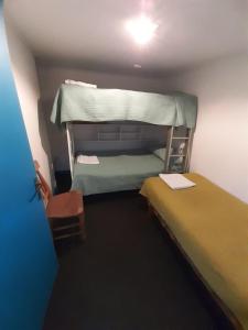 um pequeno quarto com duas camas e um beliche em CASONA CENTRO ZAPALLAR 12 personas em Zapallar