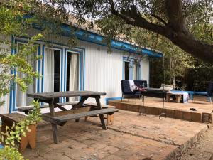 uma mesa de piquenique e um banco em frente a uma casa em CASONA CENTRO ZAPALLAR 12 personas em Zapallar