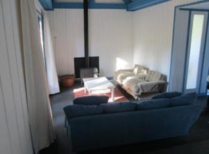 uma sala de estar com um sofá e uma mesa em CASONA CENTRO ZAPALLAR 12 personas em Zapallar