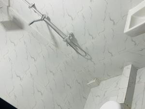 ルアンダにあるRelax Guest Houseの白い大理石の壁のバスルーム(トイレ付) +5枚の写真