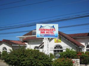 un cartello per un motel di fronte a un edificio di Fisherman's Inn Hotel a Florence Hall