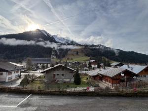 ein Dorf mit einer Kirche und einem Berg in der Unterkunft Studio lumineux avec terrasse à La Chapelle-d'Abondance - FR-1-692-107 in La Chapelle-dʼAbondance + 4 Fotos