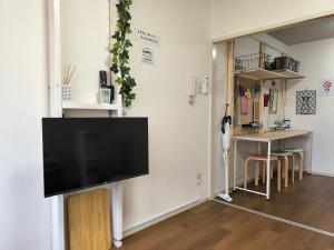 a living room with a flat screen tv on a wall at skyroom ijiri102 in Itazuke