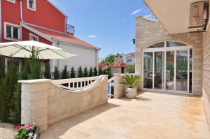 a patio with an umbrella next to a house at Apartment House Jerko in Kaštela