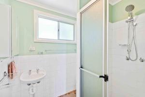 a bathroom with a sink and a shower at Retro Retreat in Manyana +12 photos