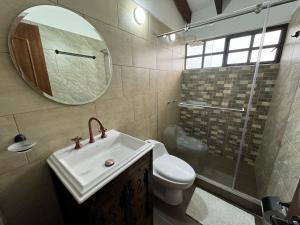 a bathroom with a sink and a toilet and a mirror at Mi terrunio-Alojamiento rural in Duitama