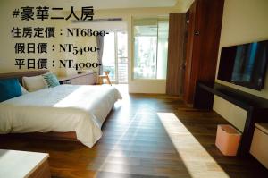 a bedroom with a bed and a flat screen tv at Lake B&B in Yuchi
