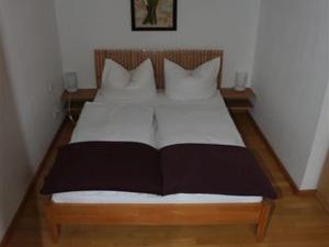 1 dormitorio con 1 cama grande con sábanas y almohadas blancas en Romantikappartements Staufen, en Staufen