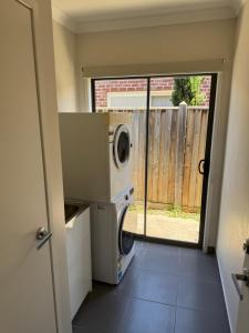 a laundry room with a washer and dryer in a house at Mahzan on Dromana Room 2 in Truganina