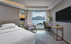 una camera d'albergo con letto, scrivania e TV di InterContinental Grand Stanford Hong Kong by IHG a Hong Kong