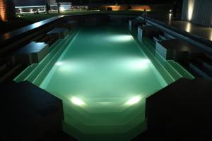 a swimming pool lit up at night with lights at Mavi Retreat in Badami +24 photos