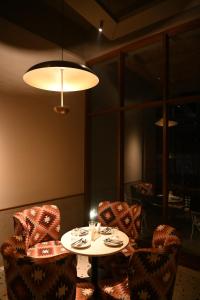 a room with a table and two chairs and a lamp at Mavi Retreat in Badami