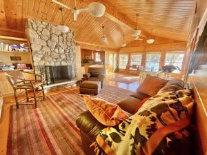 a living room with a couch and a stone fireplace at BEAR POINT LIMIT 15 villa in Harrison