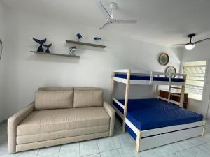 a living room with a bunk bed and a couch at Pé na Areia Praia das Toninhas - Villagio 17 in Ubatuba