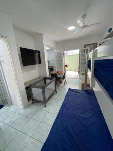 a bedroom with a bed and a table and a tv at Pé na Areia Praia das Toninhas - Villagio 17 in Ubatuba