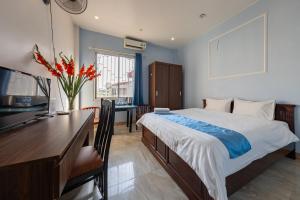 a bedroom with a bed and a desk and a table with a computer at Hanoi Capital Hotel & Spa in Hanoi