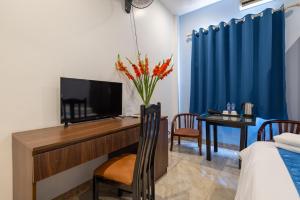 a room with a desk with a television and a bed at Hanoi Capital Hotel & Spa in Hanoi