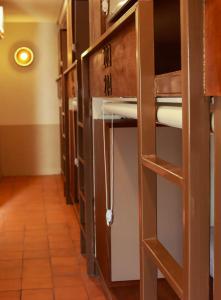 a hallway of a prison cell with open doors at Shanti Hostel in Chiang Mai