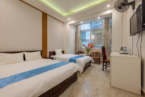 a hotel room with two beds and a television at Hanoi Capital Hotel & Spa in Hanoi +8 photos