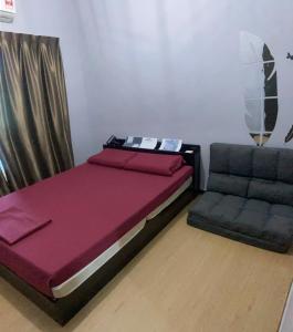 a bed and a chair in a room at Sandakan Js homestay in Sandakan