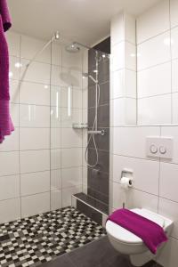 a bathroom with a toilet and a glass shower at Hotel Berg in Dannenfels