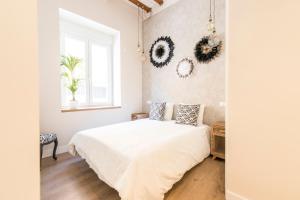 a white bedroom with a bed and a window at Loft chic luminoso in Madrid