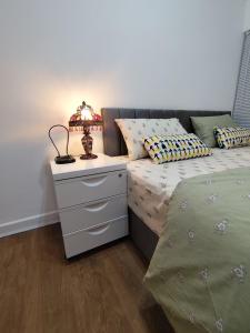 d'un lit avec une table de nuit et une lampe. dans l'établissement Prime Apartment, Wigan, UK, à Ince-in-Makerfield
