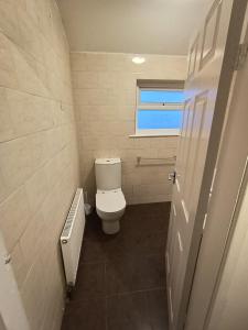 une petite salle de bain avec toilettes et fenêtre dans l'établissement Prime Apartment, Wigan, UK, à Ince-in-Makerfield