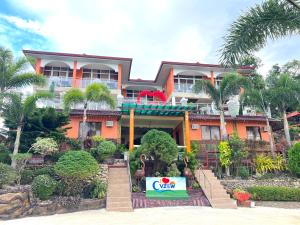 una casa grande de color naranja con un cartel delante en C View Resort, en Sipalay