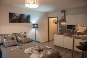 a living room with a couch and a kitchen at Villa Lympia in Nice