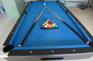 a pool table with two cue sticks and balls at Utopía in Balneario Argentino