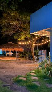 a pavillion with a straw umbrella and a tree with lights at ELEN INN - Malapascua Island - Air-condition Room - SHARED TOILET AND BATH ROOM #5 in Malapascua Island +23 photos