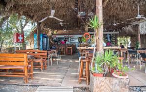 a restaurant with wooden tables and chairs and a bar at Megim Hotel in Palaiochora