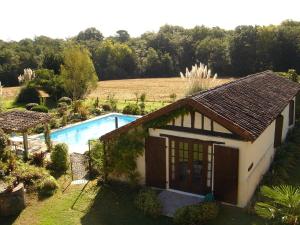 una pequeña casa con piscina junto a un campo en Grand Hourcqs en Pouillon