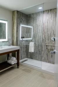 a bathroom with a glass shower with a sink at Courtyard by Marriott Lake Jackson in Lake Jackson