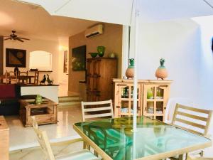 a living room with a glass table and chairs at Deluxe Family Comfort Balcony Room with Pool Playacar Ii in Playa del Carmen