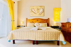 a bedroom with a bed with a dress on it at Deluxe Family Comfort Balcony Room with Pool Playacar Ii in Playa del Carmen +38 photos