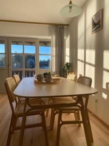 a dining room with a wooden table and chairs at Appartement am See in Haidmühle