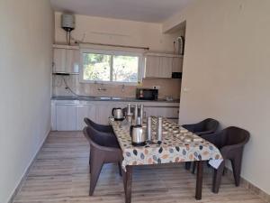 a dining room table with chairs and a kitchen at Johaar Retreat, Bhimtal in Bhowāli