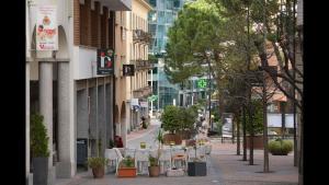 an empty city street with tables and potted plants at Bright Stunning Central Apartment In Front Of Lugano Lake in Paradiso
