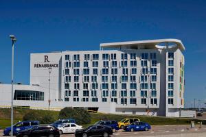 ニスクにあるRenaissance Edmonton Airport Hotelの駐車場車が停まった白い建物