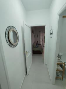 a hallway with a mirror and a room with a bed at Villa Playa in Novo Sancti Petri
