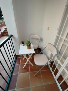 a small balcony with two chairs and a table at Villa Playa in Novo Sancti Petri