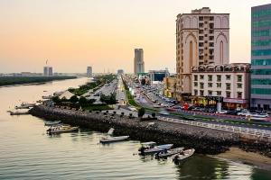 een stad met boten in het water en gebouwen bij Stunning Corniche view in Ras al Khaimah