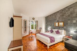 a bedroom with a king sized bed and a tv at Sterling Kodai Lake in Kodaikānāl +261 photos