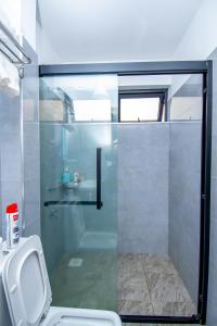 a bathroom with a glass shower with a toilet at Sweet home in Nairobi