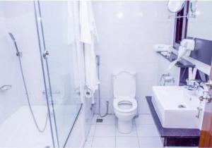 a bathroom with a shower and a toilet and a sink at Limewood Hotel Presidential Suite in Port Harcourt +29 photos