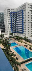 an overhead view of a pool with palm trees and buildings at Sea Residences Xyrille in Manila