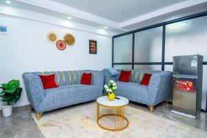 a living room with two blue couches and a table at Sweet home in Nairobi