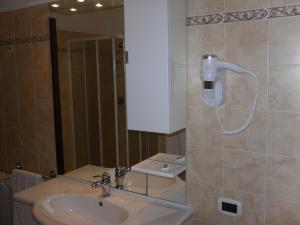 een badkamer met een wastafel en een telefoon aan de muur bij Agriturismo il Giardino in Saturnia
